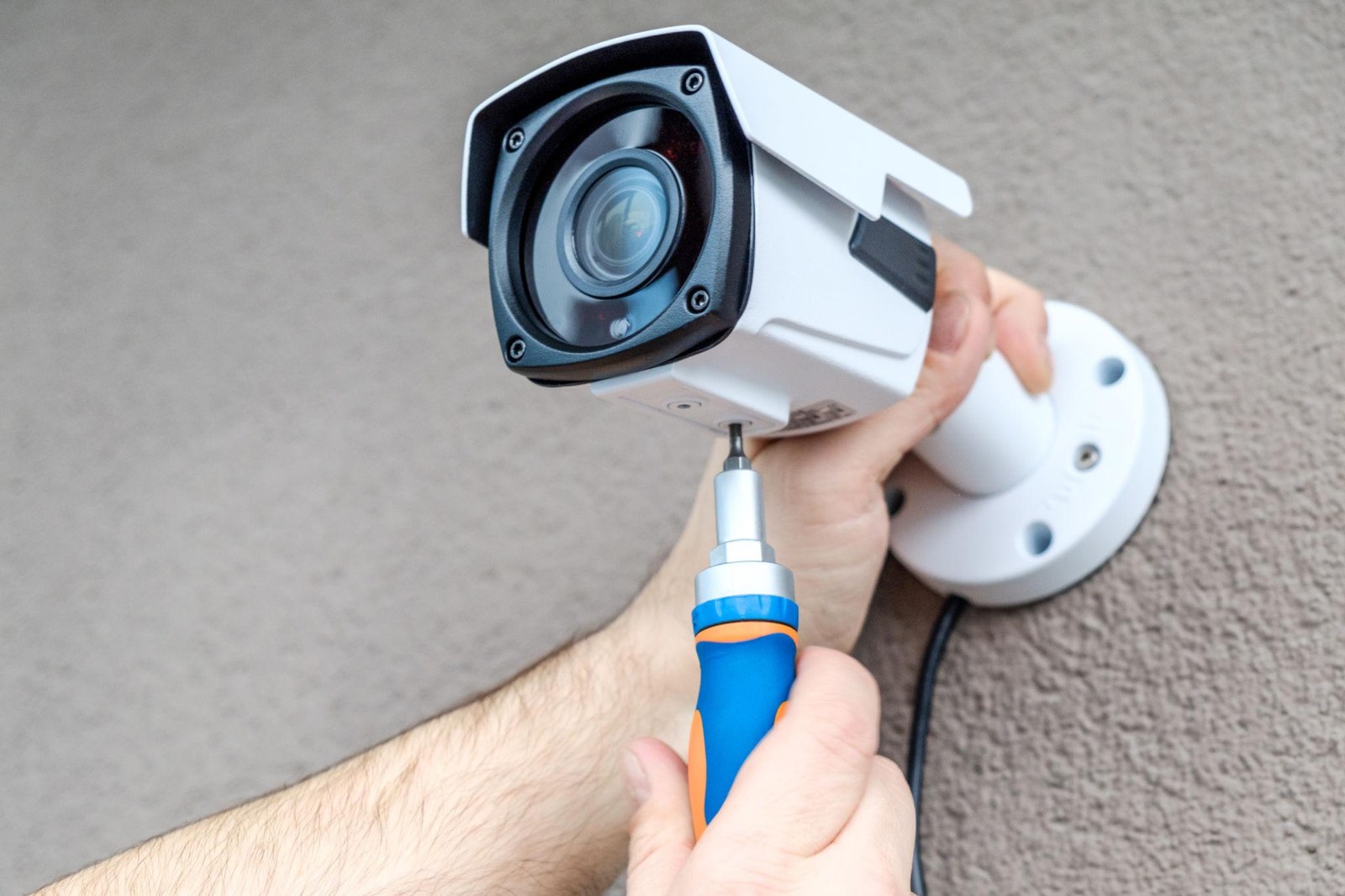 Engineer fitting a CCTV bullet camera to a wall in Barking
